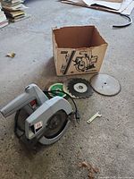 Saw, three blades, wrench, box on floor