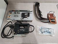 Jig saw with power cord, original box, belt, extra blades in plastic