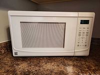 Front view of Kenmore white countertop microwave closed