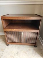 Front view showing open shelf, slatted doors, casters