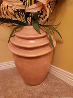 Peach ceramic vase with tiered neck detail and faux flowers