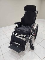 Front three-quarter view of wheelchair showing seat, footrests and headrest