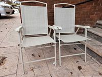 Front view of both folding beige patio chairs