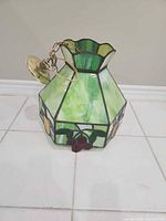 Stained glass pendant lamp showing brass canopy and chain attached
