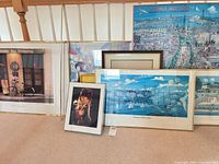 Group shot of all eight framed art pieces leaning against railing