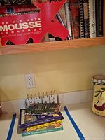 Shelf with numerous cookbooks, including The Ultimate Mousse Cookbook