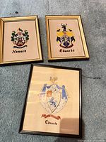 All three framed family crest prints on carpet