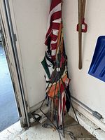 Full view of stand holding umbrellas and flag