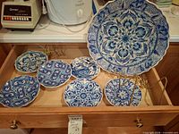 All seven plates and several gold stands in drawer