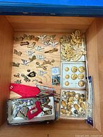 Drawer view showing full assortment: collar pins, hat badge, two boxes of buttons, ribbon bars, red cloth backing