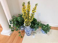 Group view of vase and three planters with faux greenery and flowers