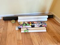Stack of five rolled posters, black tube and green Gamefisher container