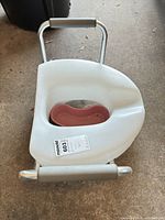 Top view of Lumex raised toilet seat showing padded handles and splash guard