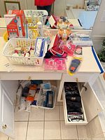 Overview of vanity with Dentaguard box, toiletries basket, cotton squares, reading glasses in cabinet