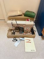 Overall view of Nelco sewing machine in case with accessories