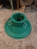 Top view of green plastic tree stand showing central trunk holder and wing bolts