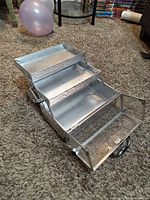 Case open with tiered fold-out trays extended, interior view