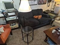 Lamp with glass shelves beside sofa and other furniture