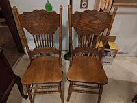 Front view of two matching solid oak dining chairs