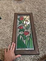 Front view of stained glass panel lying flat showing full floral design and condition