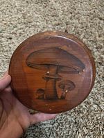 Front view of round wooden plaque with mushroom print showing surface wear