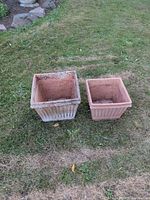 Both square terracotta planters side by side on lawn