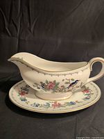 Right side view of gravy boat on saucer showing pattern and condition