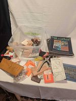 Overview of lot showing bin with stamping tools, mallet, leather blanks, packaged accessories, magazines