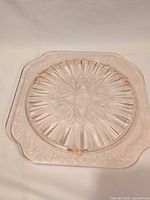 Top view of pink square footed cake plate showing Adam pattern and radiating lines