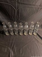Front view of seven glass bottles in metal holder