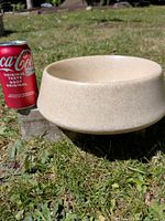 Stoneware bowl next to soda can showing exterior shape and size