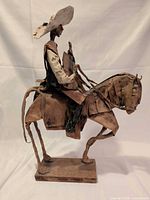 Full right-side profile of paper mache rider on horse