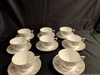 Eight cup and saucer sets arranged to show pattern and quantity