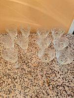 Group of 11 matching cut crystal wine glasses on countertop