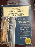Harmonica package with instruction book visible showing branding and instructional details