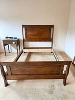 Full view of assembled bed frame showing headboard, footboard, rails and slat