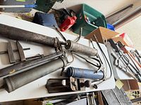 Group of grease guns, hacksaw frame, block plane, small clamp