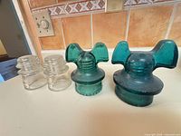 Group of four glass insulators: two aqua wing-top Hemingray, two clear standard style