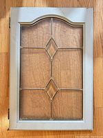 Full view of cabinet door front showing frame, leaded glass diamond design