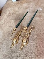 Pair of brass wall sconces with green candles on carpet
