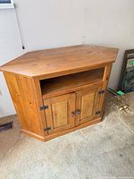 Front view showing open shelf, double doors, black hinges