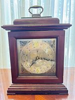 Full view of clock showing wooden case and handle
