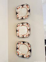 Three shaped dinner plates mounted on wall