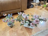 Two glass floral arrangements on floor showing overall size and bases