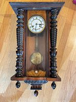 Full front view showing case, dial, columns and pendulum