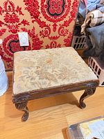 Three-quarter view showing upholstery and carved legs