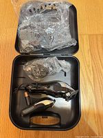 Open carrying case showing corded clipper, trimmer, power cord, and bag of clipper guards