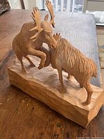 Full view of carved moose sculpture from front left showing detail and base