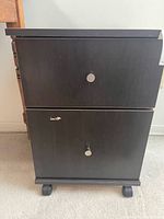 Front view showing two drawers, pull knobs, casters visible