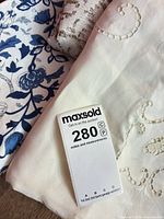 Folded cream and brown crochet cloths with blue floral tablecloth